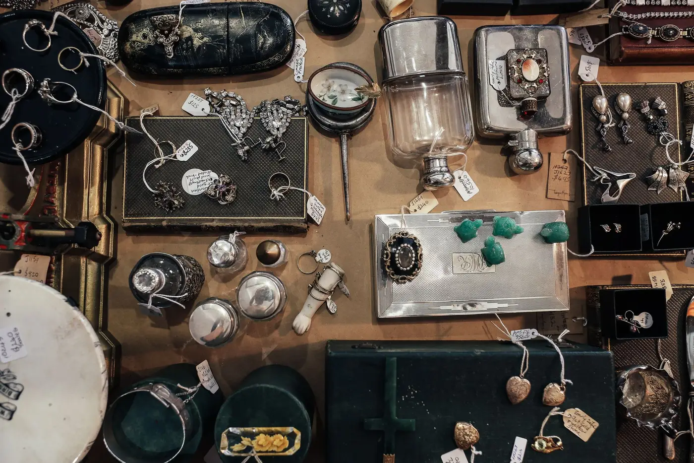 A table of mixed antique and collectible lots laid out for a sale preview