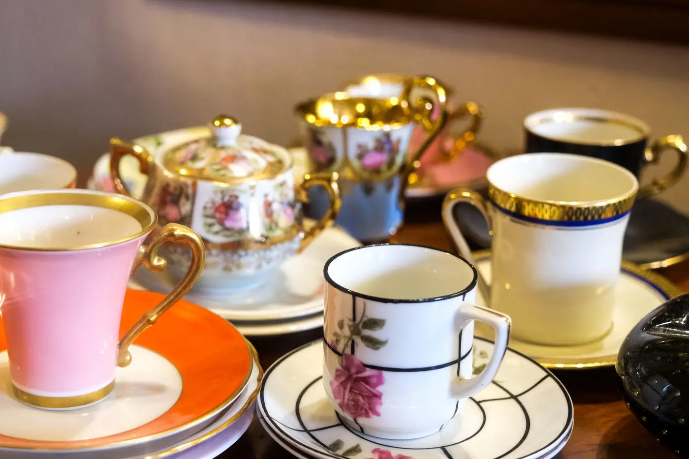 Vintage porcelain teacups and saucers laid out on a table for viewing